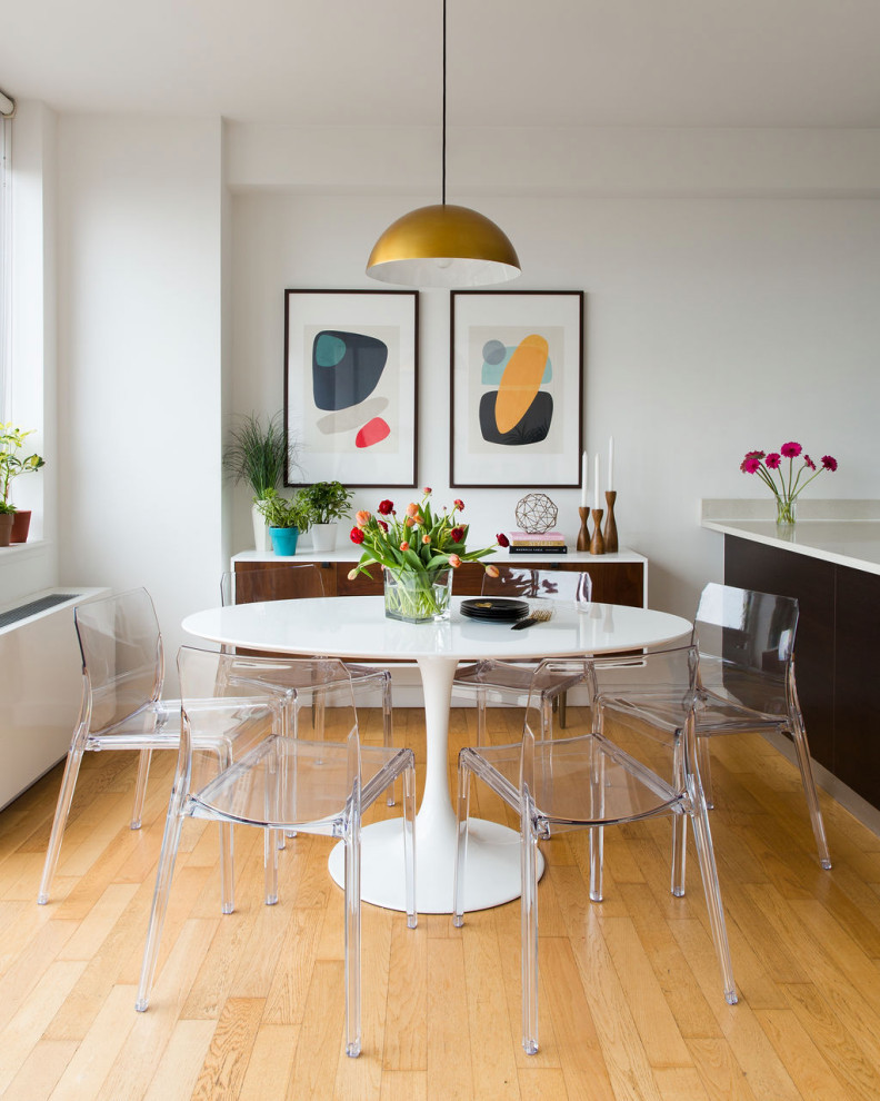 Sunlit Modern Dining Room: Geometric Art, Transparent Seating & Golden Accents